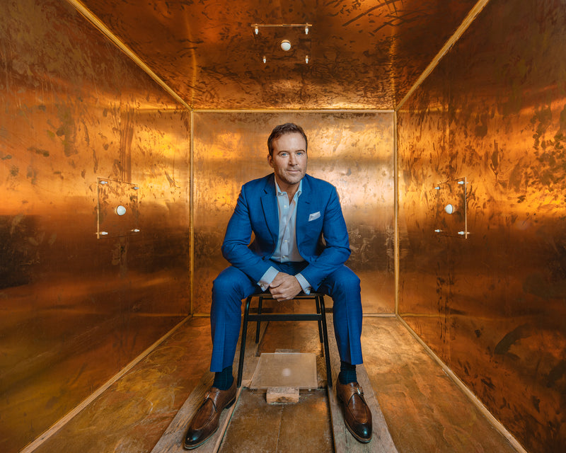 Ben Johnson MD sitting on a chair inside a copper box