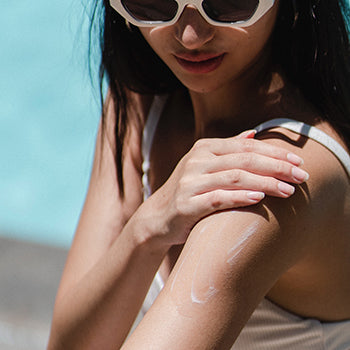 Woman putting on sunscreen