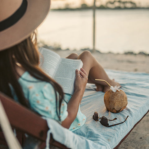 Woman reading a book at the beach